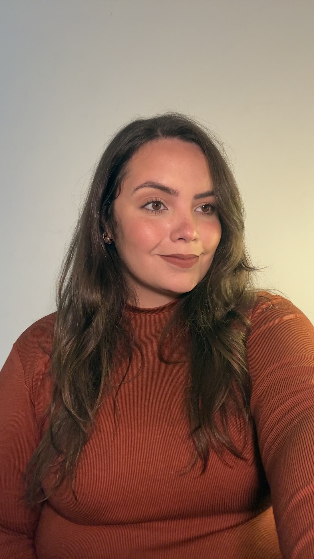 Retrato de Emilly Pestana, de lado, com blusa terracota